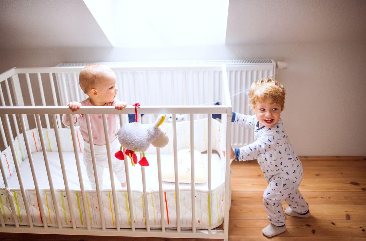 two-toddler-children-in-bedroom-at-home-6mxdfjz.jpg